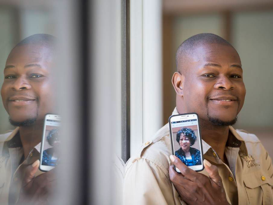 Kidney transplant recipient Khris Downing holds a cell phone photo of his sister, Geraldine, whose kidney he received. 