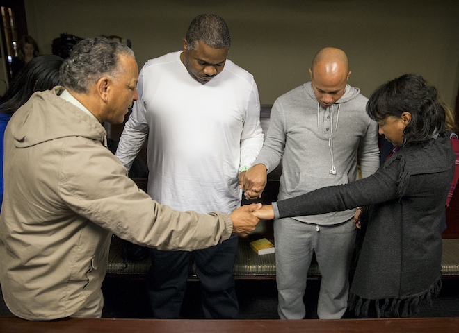 Chip Davis and Eric Crowder pray with family and friends before a kidney transplant operation. 